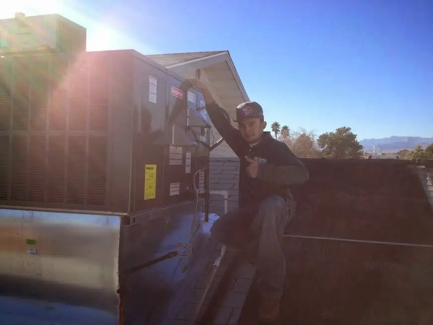 HVAC technician performing Boiler Repair on a rooftop unit in Spencer